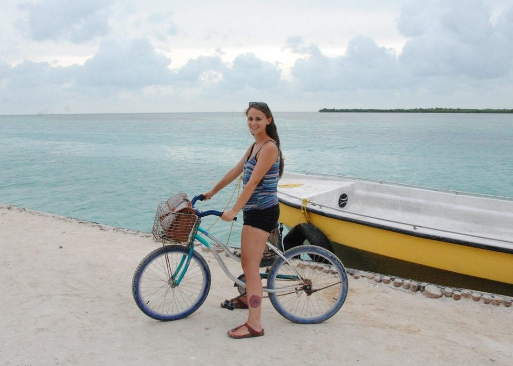 Student on bike in front of boat